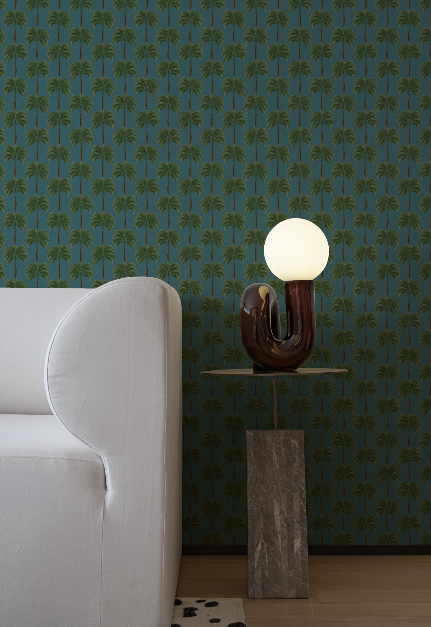 A white couch and lamp with Designer Deus ex Gardenia painted Little Palma Wallpaper in Lagoon. Photographed by Xie Yujie Nick.