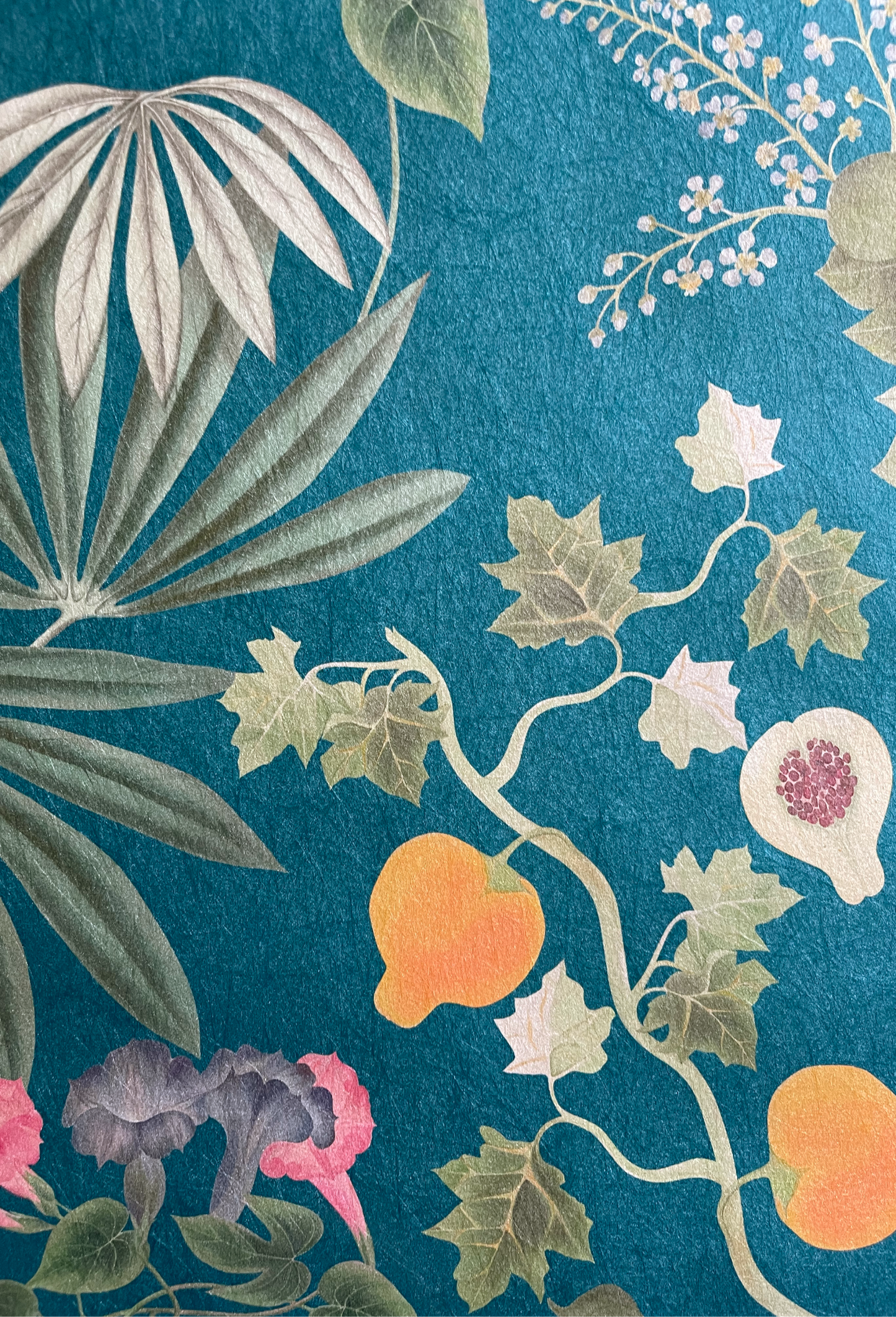 Fruit surrounded by flowers and leaves of the Eden Wallpaper in Cornflower Blue by Deus ex Gardenia.