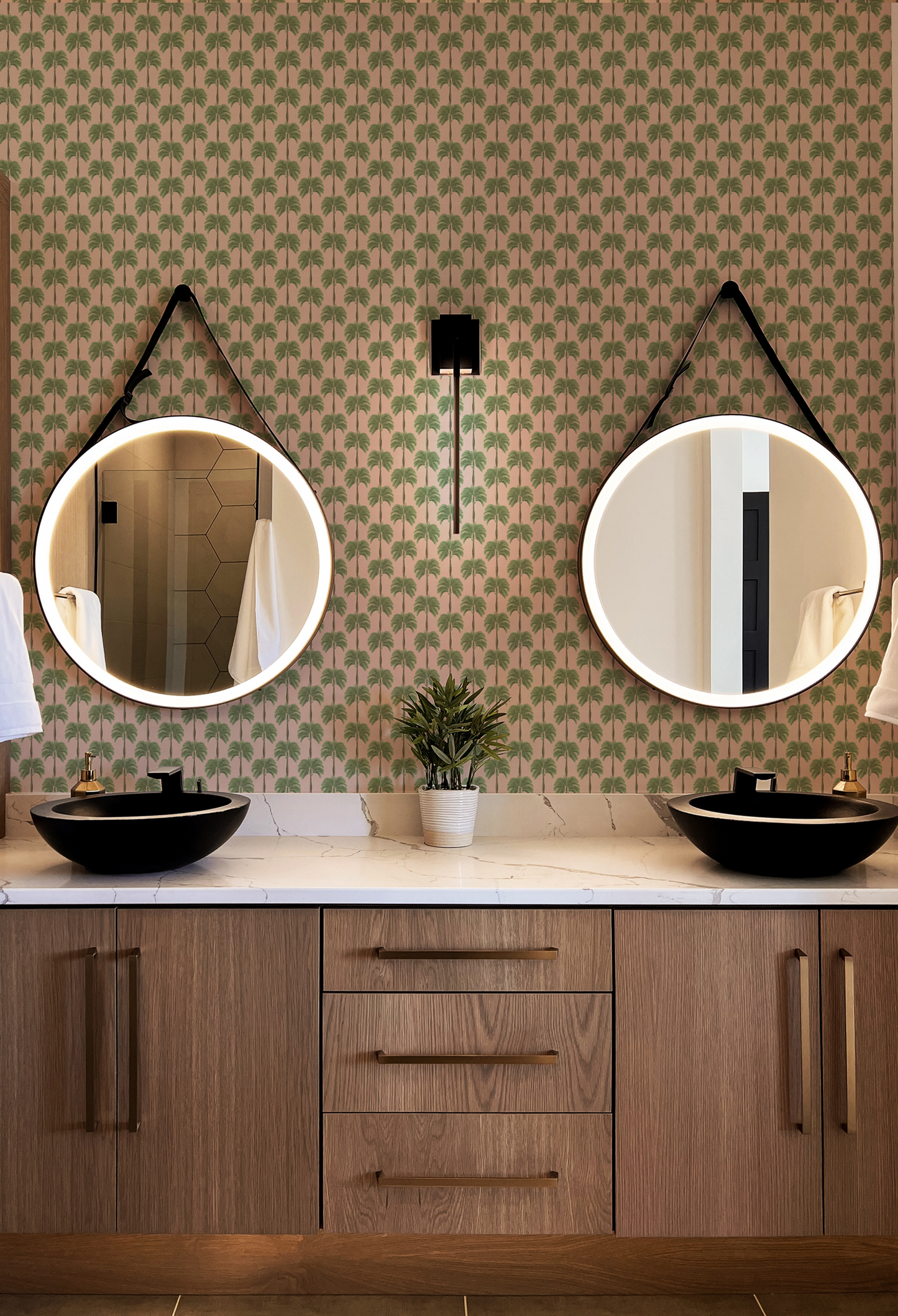 Modern bathroom with two round mirrors, surrounded by Little Palma luxury wallpaper by Deus Ex Gardenia in Flamingo pink 